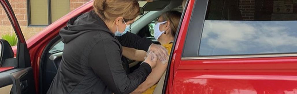 Patient receiving vaccine in their car